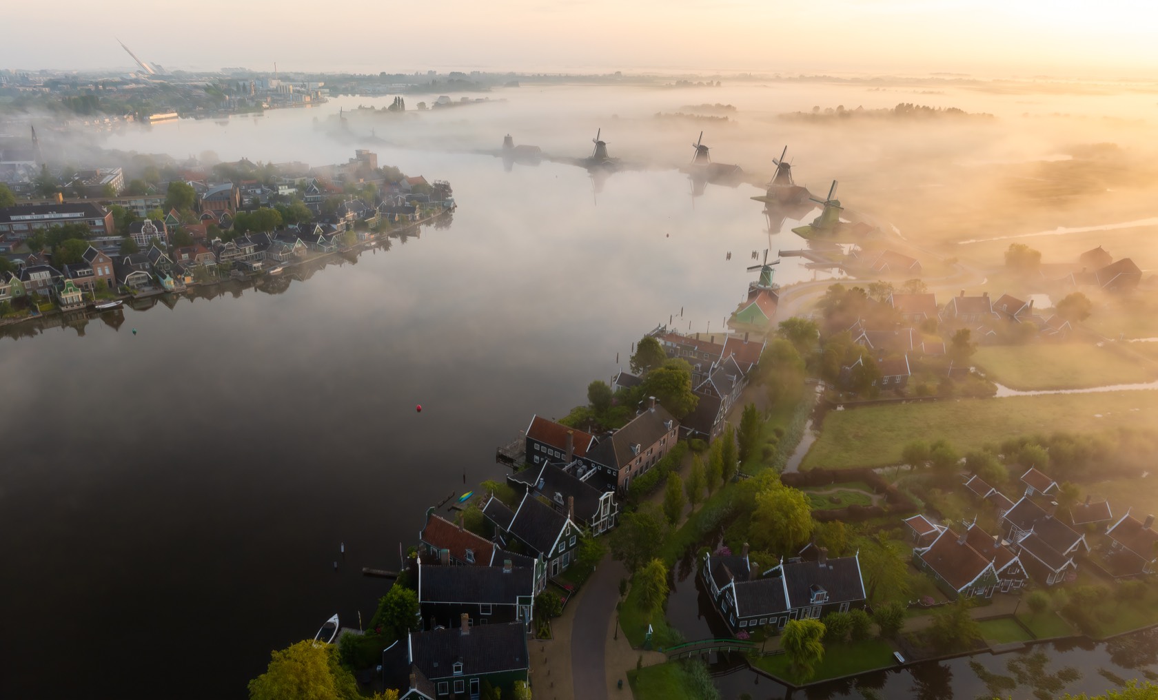 Mist drifting over a river valley at dawn, seen from above