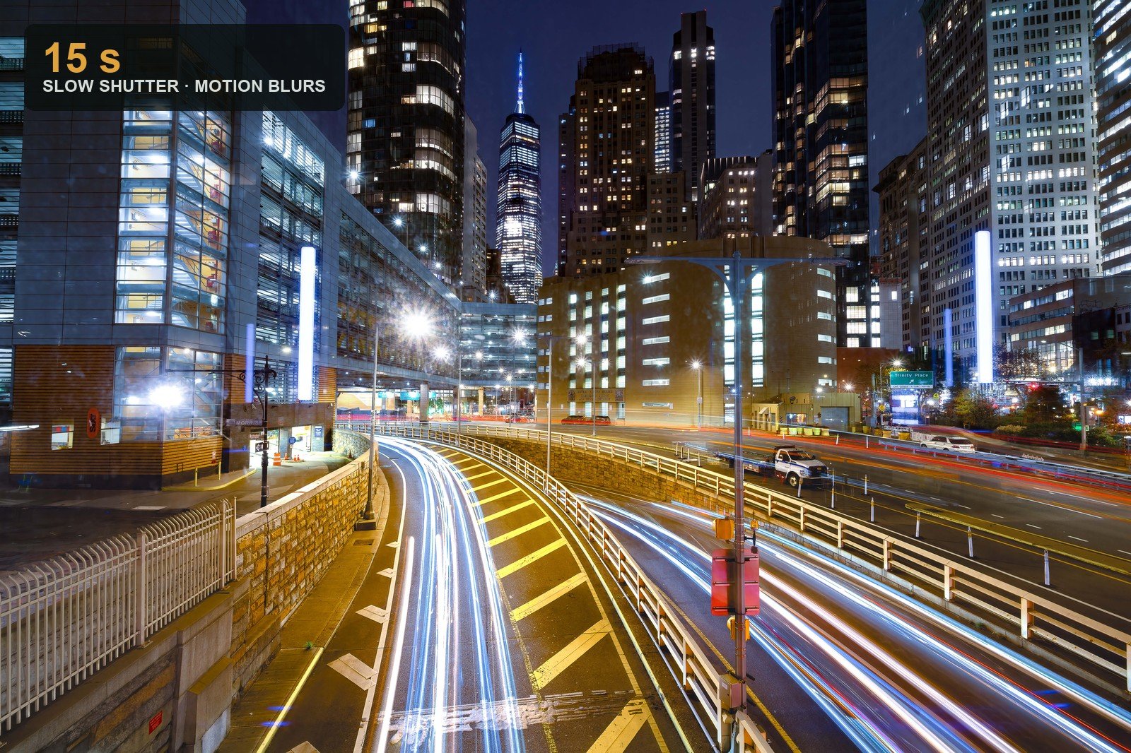 Long red and white car-light trails streaking through a night city toward the skyline — a 15-second slow-shutter exposure that turns motion into ribbons of light