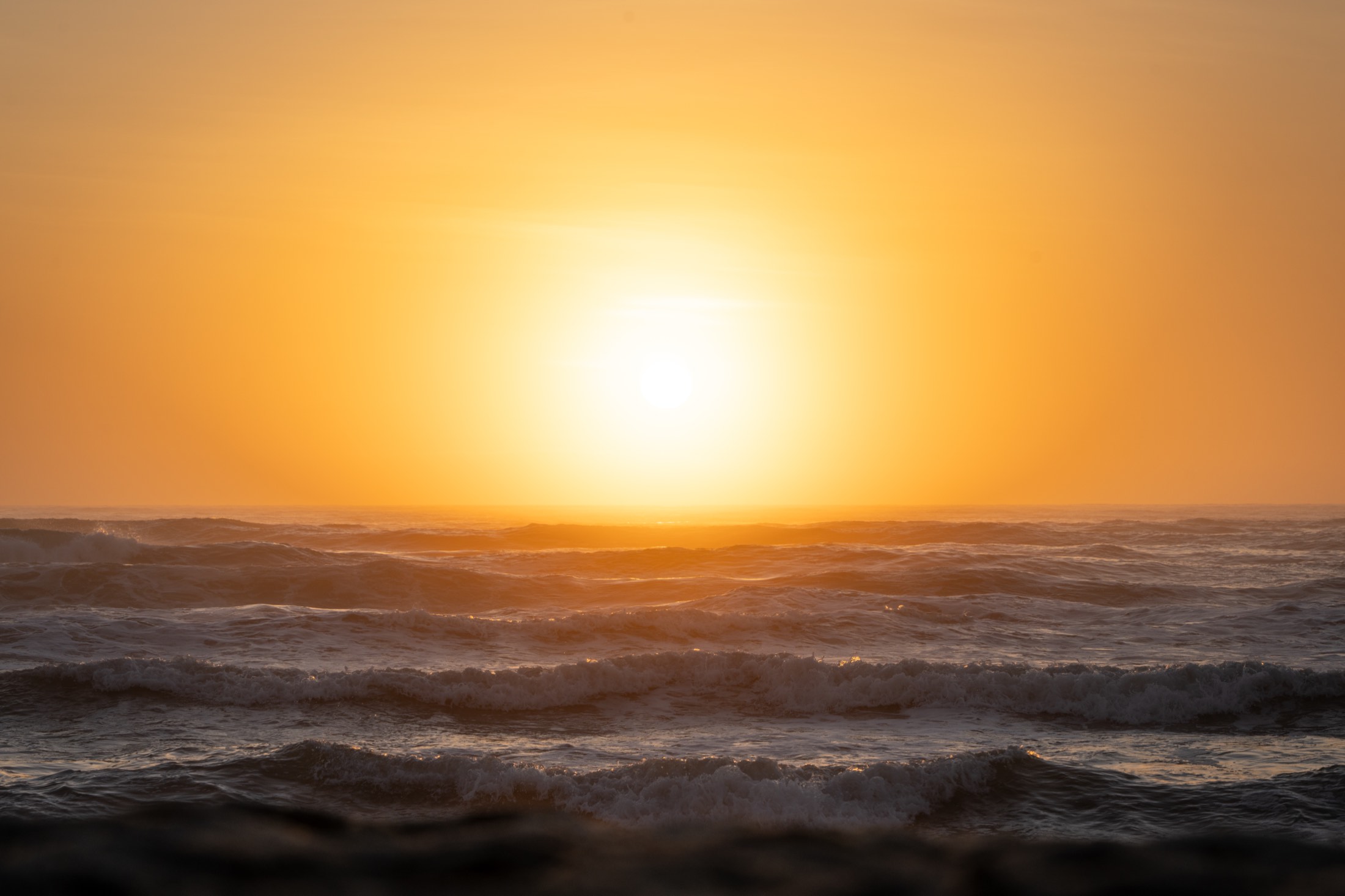 Golden sunset light over ocean waves